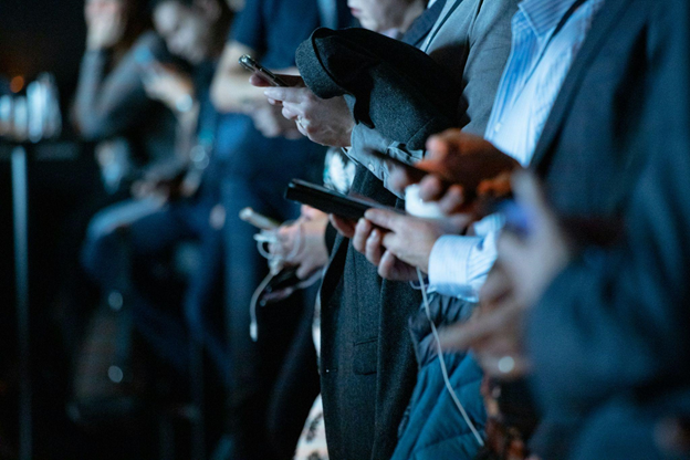 People all focused on their smartphones, conveying a sense of connectivity and modern engagement.